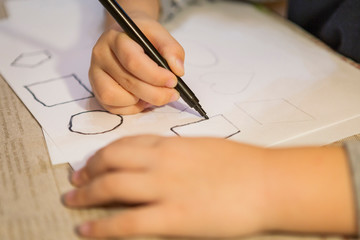 Naklejka premium child painting and coloring figures on white sheet at home. 