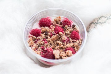 Healthy dessert with raspberries in plastic cup