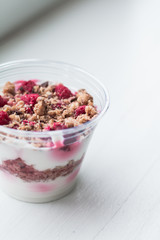 Healthy dessert with raspberries in plastic cup