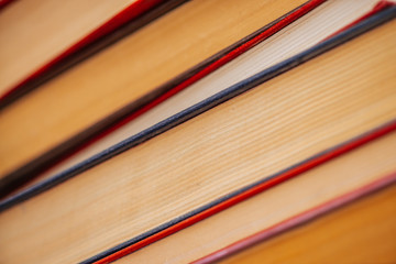 Vintage books close-up. Stack of used old literature in school library. Background from old chaotic reading matter. Dusty faded books diagonally with copy space. Old book store.