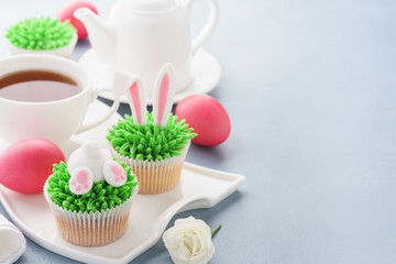 Easter background with bunny cupcakes and tea for breakfast.