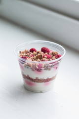 Healthy dessert with raspberries in plastic cup