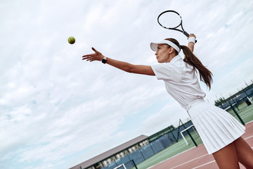 Develop your skills. Attractive sportswoman throws the ball into the air