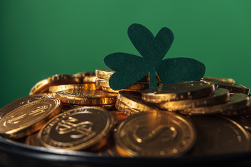 shiny golden coins with shamrock isolated on green, st patrick day concept