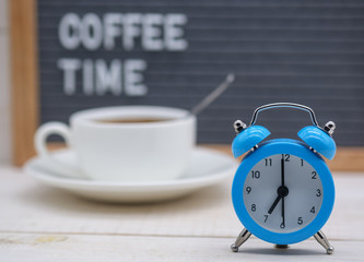 Fototapeta na wymiar blue alarm clock on a background of coffee and decals coffee time