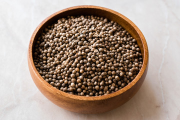 Organic Dried Coriander Seeds in Wooden Bowl.