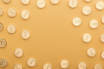 top view of shiny golden coins with dollar signs isolated on orange with copy space, st patrick day concept