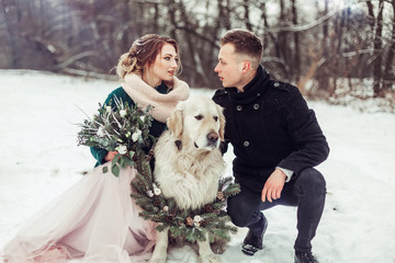 Wedding romantic couple in winter hugging outdoors in park with dog labrador. Love, happiness, beauty, wedding concept