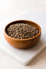 Organic Dried Coriander Seeds in Wooden Bowl.