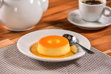 Vanilla pudim with caramel sauce on decorated scene