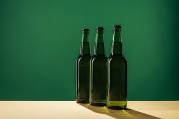 beer bottles with shadows and copy space isolated on green, st patrick day concept
