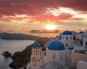 Oia village with churches against sunset on Santorini island in Greece