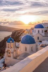 Oia village with churches against sunset on Santorini island in Greece