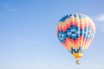 colourful hot air balloon floating in the blue sky with white clouds on a sunny day