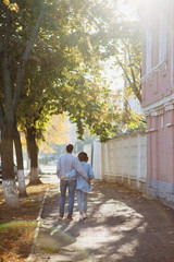 Fototapeta na wymiar Back view of young couple walking in street in autumn