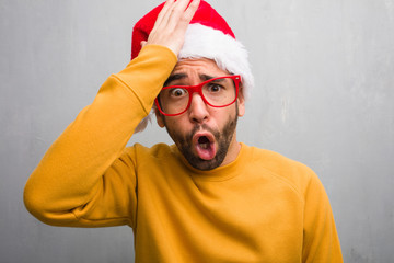 Young man celebrating christmas day holding gifts forgetful, realize something