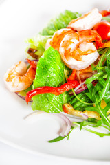 Delicious salad with shrimp, tomatoes and greenery on white