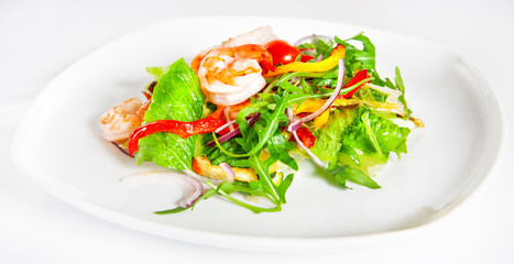 Delicious salad with shrimp, tomatoes and greenery on white