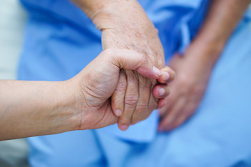Holding Touching hands Asian senior or elderly old lady woman patient with love, care, helping, encourage and empathy at nursing hospital ward : healthy strong medical concept 
