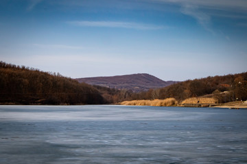Fototapeta premium Beach by the frozen lake. Beautiful sunny winter day. Sumarice lake near the Kragujevac in Serbia.