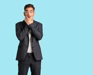 Young handsome business man surprised and shocked