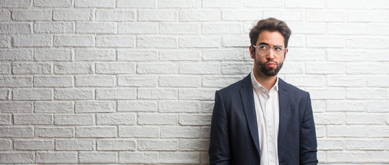 Young friendly business man doubting and confused, thinking of an idea or worried about something