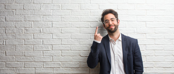 Young friendly business man showing number one, symbol of counting, concept of mathematics, confident and cheerful