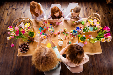 Close up top above high angle view photo three children one room making decorating eggs easter symbols weekend children day concept funny pretty cute ready celebrate holiday sit big wooden table floor
