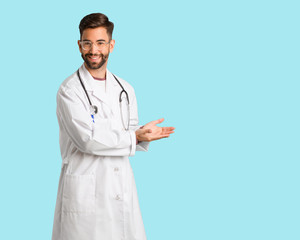 Young doctor man holding something with hands