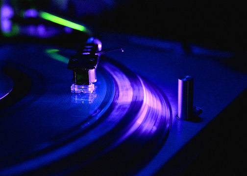 Dj playing and mixes track on Player at night club party