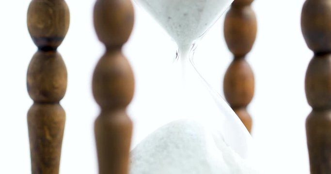 Sand falls quickly through an hourglass.