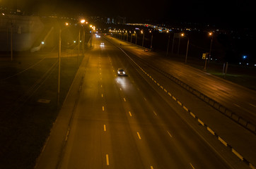 Cars drive at night on the motorway.