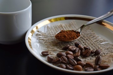 Coffee beans on a white plate on burlap.