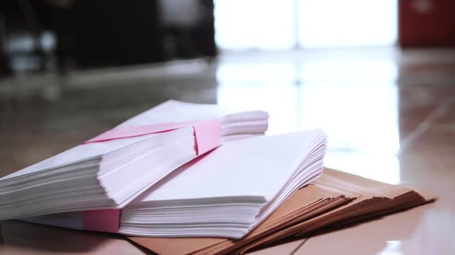 Slow motion of the bundle of documents falling from the top to the ground.