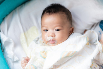 Infant baby boy vomit after eat milk on bed
