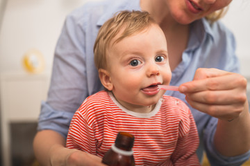 little boy taking cough syrup.