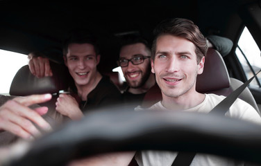 A group of people inside a car, on a road trip