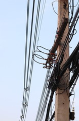 Messy electrical cables and wires on electric pole