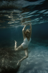 Fototapeta premium Woman in white under water in the sea