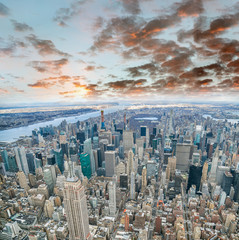 Aerial view of Manhattan skyline from the sky on a cloudy day, New York City at sunset