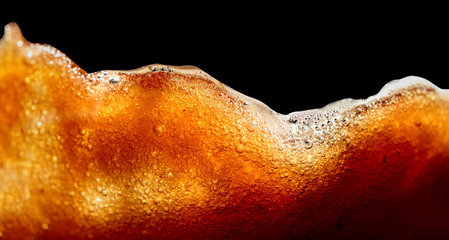 Close up of coffee splashes on a black background.