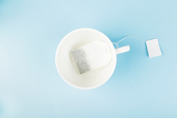 Cup of tea and tea bags on blue background. Top view. Food background