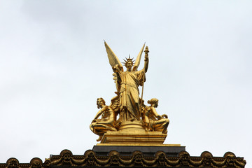 Fototapeta na wymiar Golden statue of Angel on the top of the Garnier Opera in Paris, France (The Poetry by Charles Gumery)