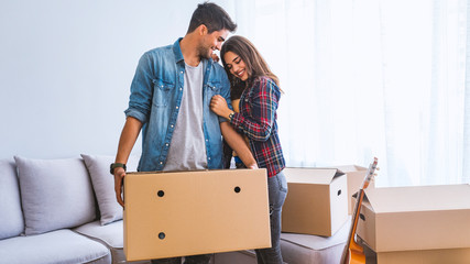 Young couple unpacking cardboard boxes at new home.Moving house.Real estate.