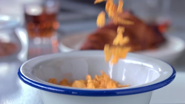 closeup slowmotion cornflakes fallin in bowl and milk then pouring on it