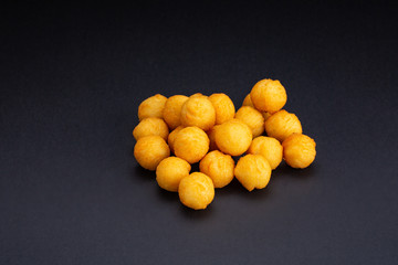 Fried potatoes balls on black background. Snack to beer.