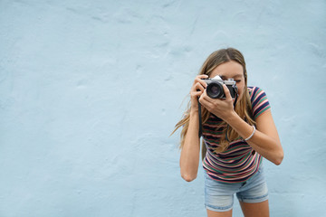 Dynamic photography student facing camera on blue background