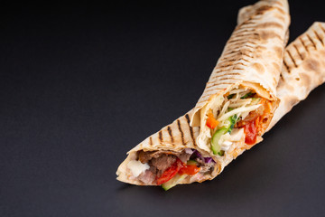 Shawarma sandwich - fresh roll of thin lavash or pita bread filled with grilled meat, mushrooms,...