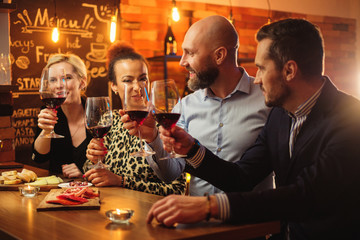 Group of friends having fun talk behind bar counter in a cafe