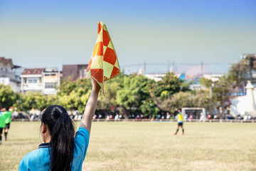 Assistant referee woman  moving along the sideline and Raise the flag during a soccer match -image